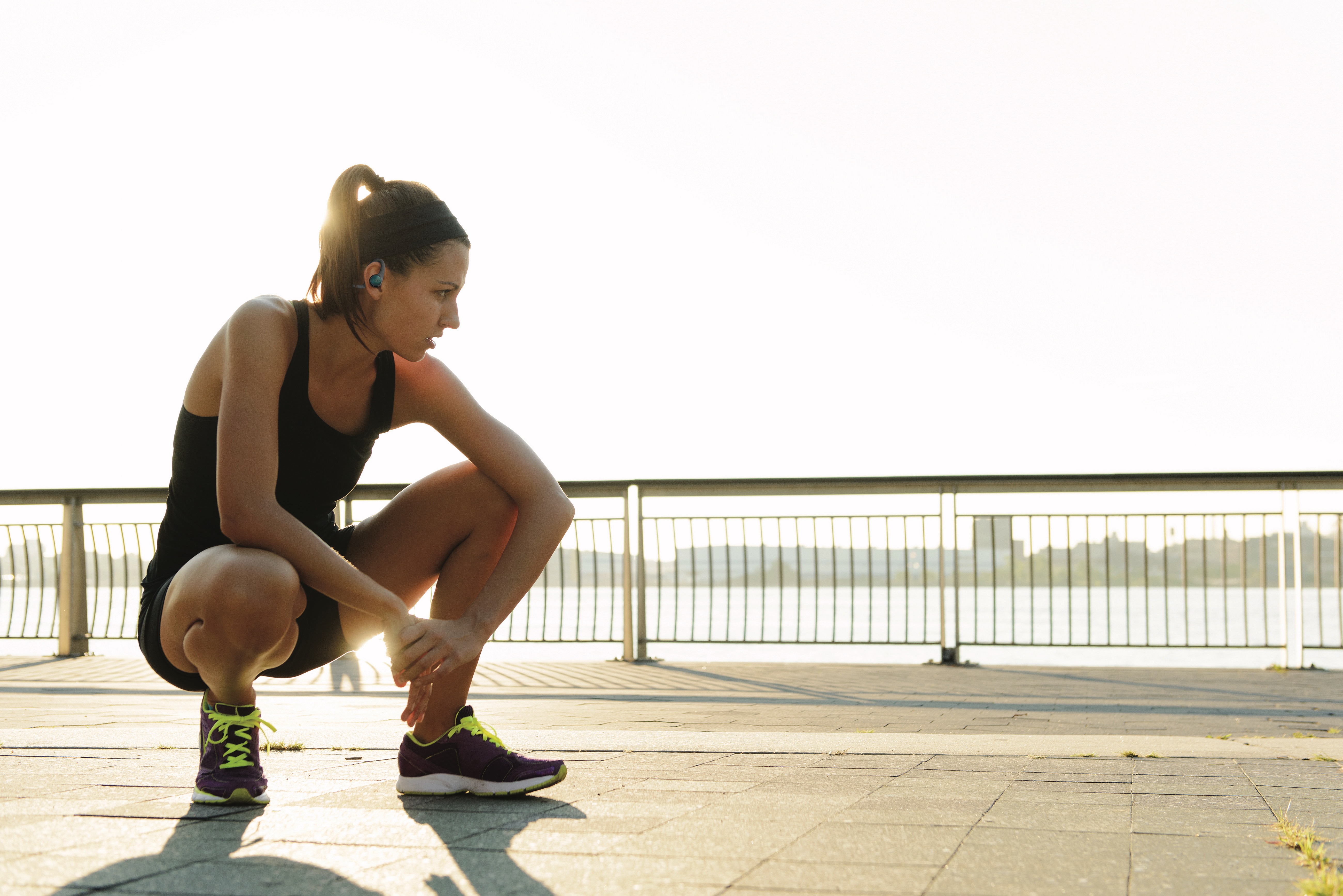 Woman Runner Crouching Wearing BackBeat FIT 2100